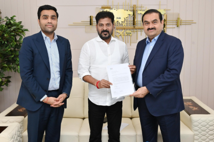 Gautam Adani presenting ₹100 crore donation to Telangana Chief Minister Revanth Reddy for Skills University establishment.